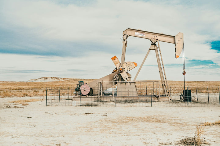 Oil pumpjack in an open landscape — illustrative stock photo
