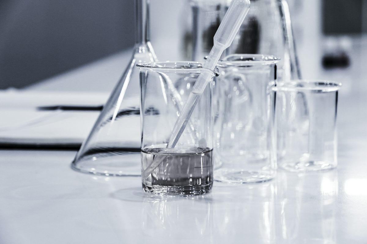 three clear beakers placed on tabletop — illustrative stock photo