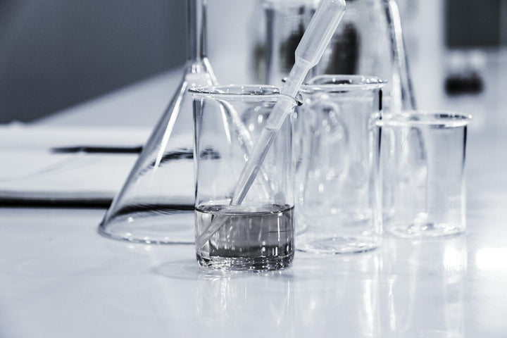 three clear beakers placed on tabletop — illustrative stock photo