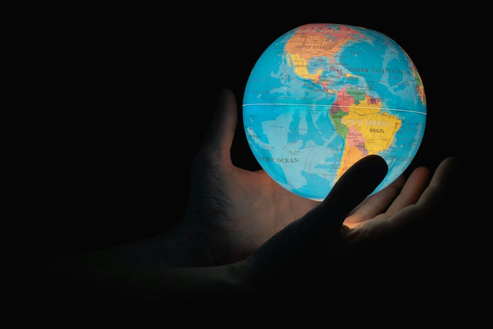 blue and brown globe on persons hand — illustrative stock photo