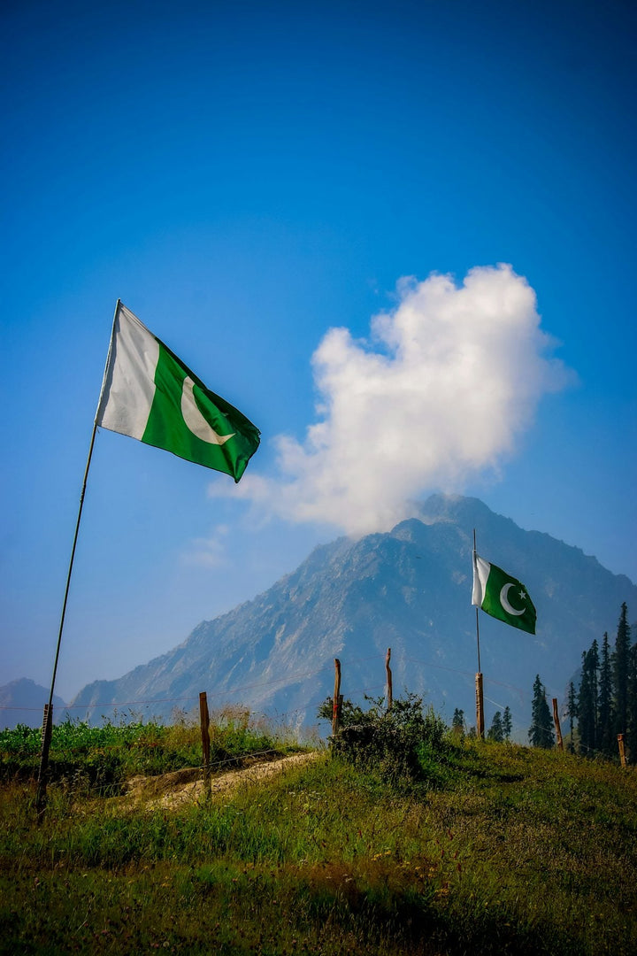 two flags flying in front of a mountain — illustrative stock photo